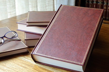 set of books set on the table, with window and library backgroundの写真素材
