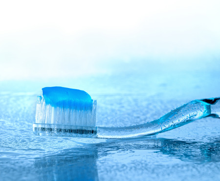 toothbrush with paste on glass with water splashes, backlightの写真素材