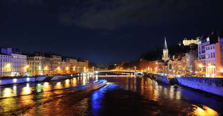Saone River with boat sailing by night and church Saint Georges on the rightの写真素材