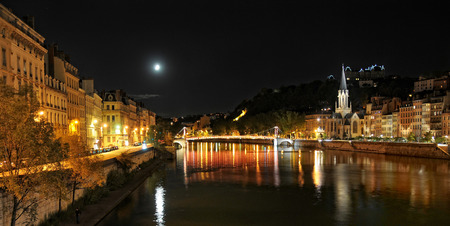 serene view of Saone river at night with church Saint Georges on the rightの写真素材