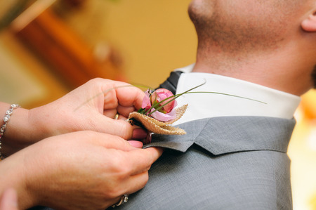 mother putting a flower in the buttonhole suit the groom on their wedding dayの写真素材