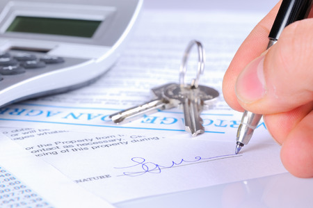 signing the mortgage contract to delivery of keys with calculator front viewの写真素材