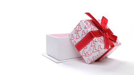 Decorative open white gift box with red ribbon and painted hearts. Front view. White isolated backgroundの写真素材