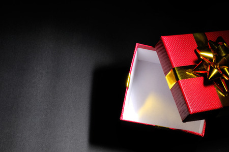 Empty open red gift box with gold bow dim. Horizontal composition. Top view.の写真素材