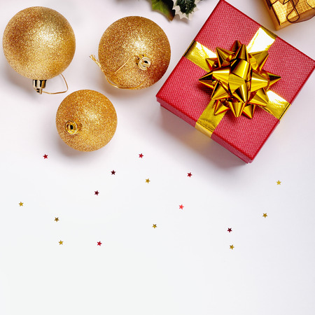 Christmas decoration isolated white. Red and golden gift boxes with three golden ball, and floral ornament. Top view. Square composition.の写真素材
