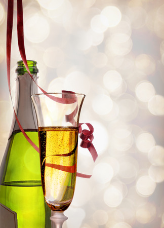 Glass and bottle of sparkling white wine with bokeh background. With red ribbons hanging . Party concept.
Vertical composition. Front viewの写真素材
