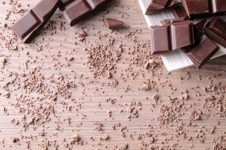 Portions and sparse chocolate chips on a white porcelain container on a brown wooden table. Horizontal composition. Top viewの写真素材