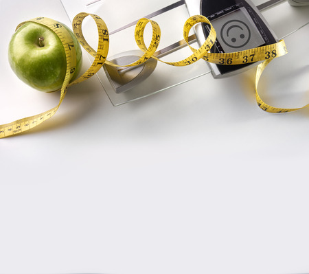 Scale with happy face message, apple and tape measure isolated. Concept health, diet and nutrition. Square composition. Top viewの写真素材