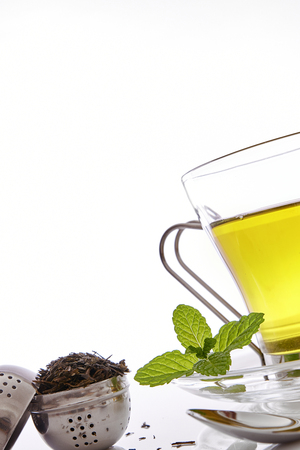 Glass cup green tea with mint and lemon on a table in the living room. Vertical composition. Front view close up.の写真素材
