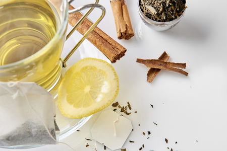 Glass cup green tea with cinnamon stick and lemon on a table in the living room. Horizontal composition. Top view.の写真素材