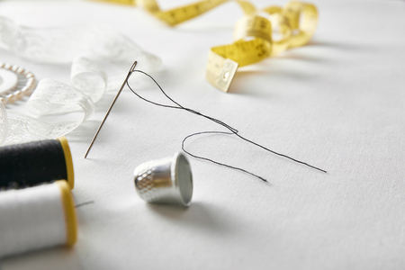 Sewing tools with lace on white fabric background. Horizontal composition. Front elevated viewの写真素材