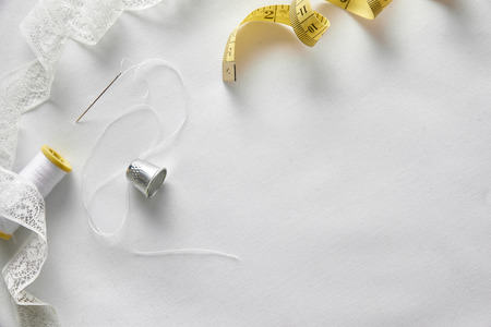 Sewing tools on white fabric background. Horizontal composition. Top viewの写真素材