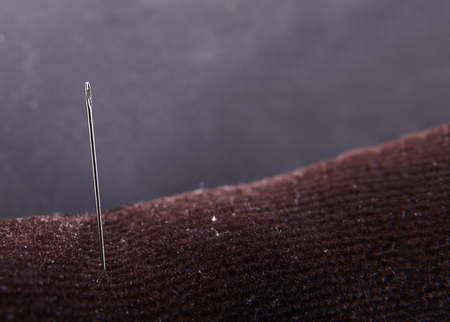 needle in an insulated pad with black background. Horizontal composition. Close upの写真素材