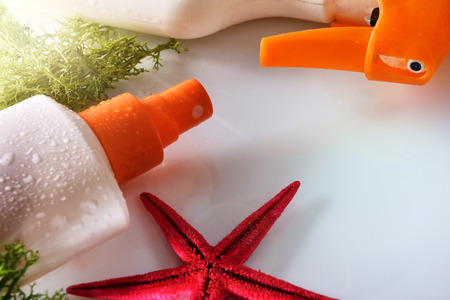 Two sunscreen spray with starfish on glass table close up. Horizontal composition. Elevated viewの写真素材