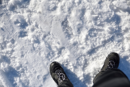 Adventure sport on snow background. Man dressed in black boots and snow pants. Top viewの写真素材