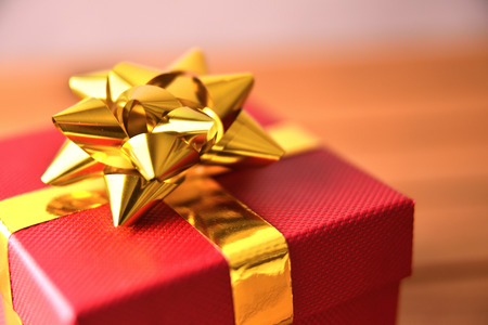 Red gift box with golden ribbon closeup. Elevated viewの写真素材
