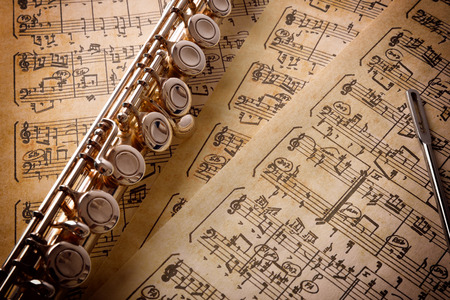 Flute with cleaning rod on old handwritten sheet music. Horizontal composition. Elevated viewの写真素材