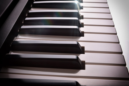 Close-up of electronic piano keyboard in twilight with shine. Horizontal Composition. Elevated side viewの写真素材