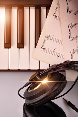 Piano keyboard in diagonal with golden shine and sheet music. Vertical Composition.Top viewの写真素材