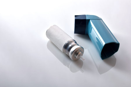 Cartridge and blue medicine inhaler on white glass table. Elevated view. Horizontal composition