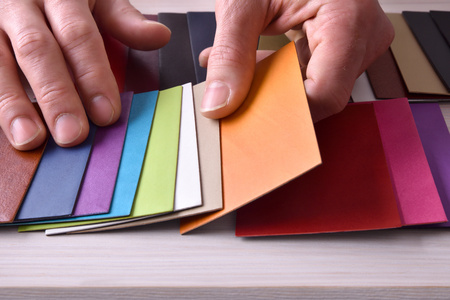 Decorator looking for materials for interior design project. Fabric and leather samples on wood table. Front elevated viewの写真素材