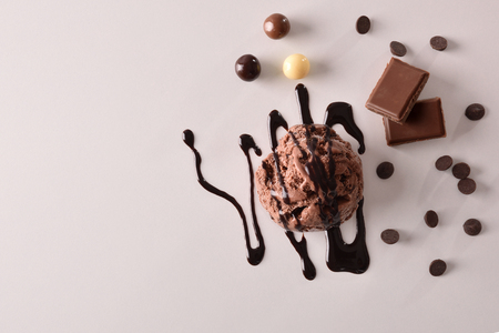 Ice cream flavored choco texture background with ball isolated on white table. Garnished with chocolate balls and squares. Top view. Horizontal composition.の写真素材