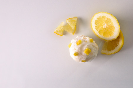 Ice cream flavored lemon texture background with ball isolated on white table. Garnished with chunks lemon fruit. Top view. Horizontal composition.の写真素材