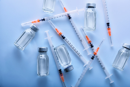 A lot of vials with medication and syringes on blue methacrylate table. Horizontal composition. Top view.の写真素材