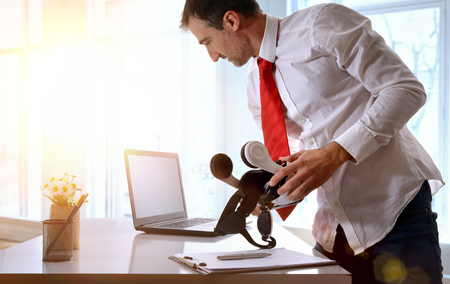 Office worker standing working with virtual reality glasses and computer in the office. Horizontal composition.の写真素材