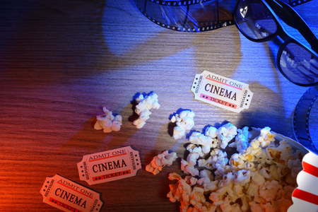 Equipment and elements of cinema on wooden table with colored lights with 3d glasses. Concept of watching movies. Horizontal composition. Top view.の写真素材