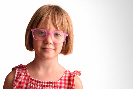 Smiling girl with large and round glasses looking straight ahead. Concept of visual correction with glasses. Horizontal compositionの写真素材