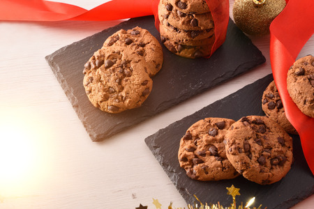 Cookies with chocolate chips on a decorated Christmas white table close up. Concept of sweet food at Christmas. Top Elevated view.の写真素材
