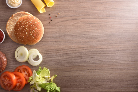 Ingredients for the preparation of a homemade burger on wooden table. Top view. Horizontal composition.の写真素材