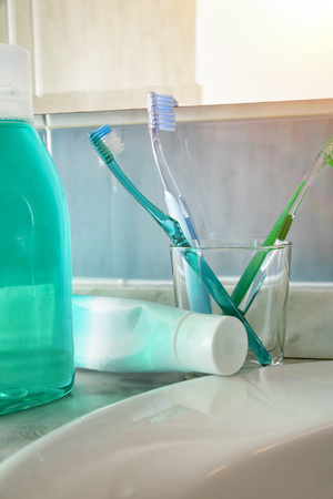 Toothbrushes, toothpaste and on a sink. Vertical composition. Front view.の写真素材