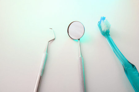Dentist tools on table with green light. Horizontal composition. Top elevated view