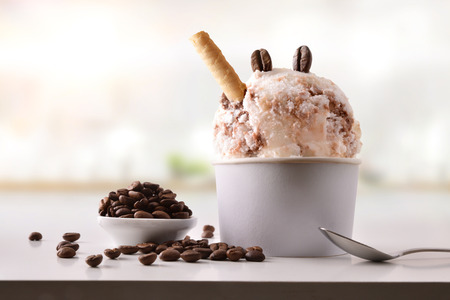 Coffee ice cream cup on white table homemade with kitchen background. Horizontal composition. Front view.の写真素材
