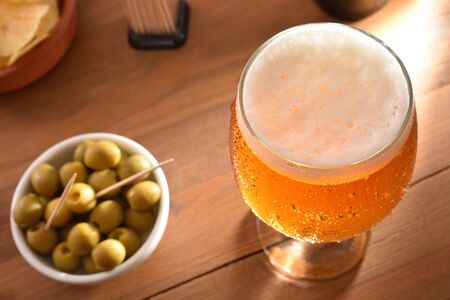 Glass beer with appetizer on wooden table top view detail. Horizontal composition. Top view.の写真素材