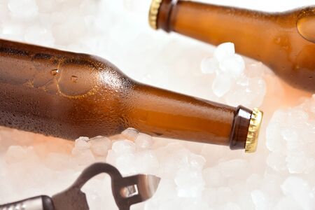 Two beer bottles on crushed ice with bottle opener close up . Horizontal composition. Top elevated view.の写真素材