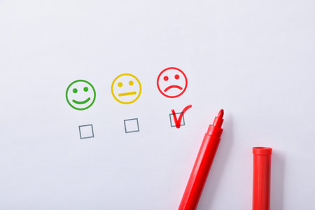 Negative satisfaction marked with red marker pen represented with colored emoticons on white paper....