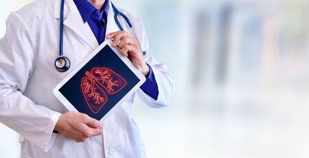 Doctor showing a picture of lungs on a tablet in a hospital. Horizontal composition.の写真素材