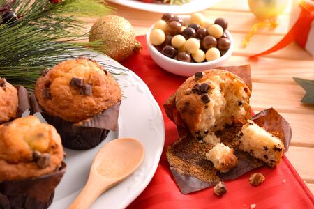 Freshly baked chocolate chip muffin on wooden table decorated with Christmas objects. Horizontal composition. Elevated view.の写真素材