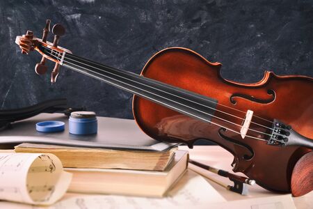 Student violin and equipment on wooden table and blackboard background. Front view. Horizontal composition.の写真素材