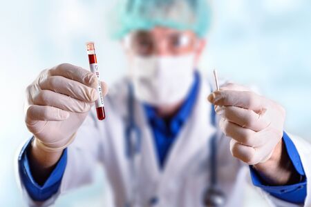 Doctor showing positive covid-19 tube test and sampling swab with protective glovesの写真素材