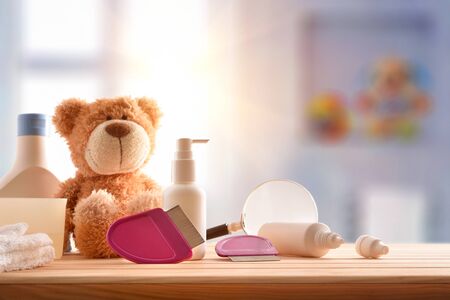 Treatment and prevention of lice with equipment on wooden table in children's room. Horizontal composition. Front view