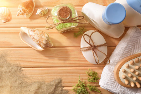 Thalassotherapy products for body treatment on wooden slats table decorated with seaweed shells and...