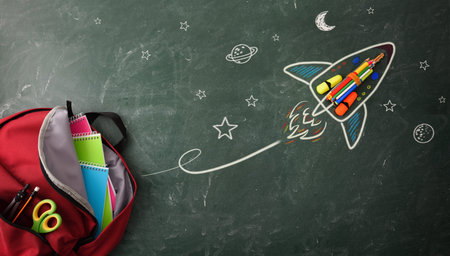 School creativity with drawing on blackboard with colored pencils and school supplies in backpack....