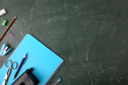 Background with office supplies and teaching material on green blackboard top viewの写真素材