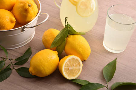 Freshly prepared lemon with water beverage with utensils on wooden rustic kitchen bench. Top elevated view. Horizontal composition.の写真素材