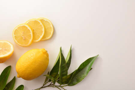 Background with cut and sliced organic lemon on a white table. Top view. Horizontal composition.の写真素材