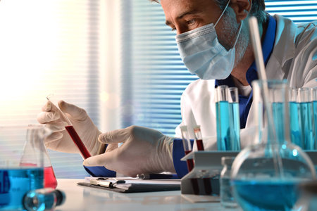 Medical laboratory technician analyzing blood samples in testing room. Horizontal composition. Front...